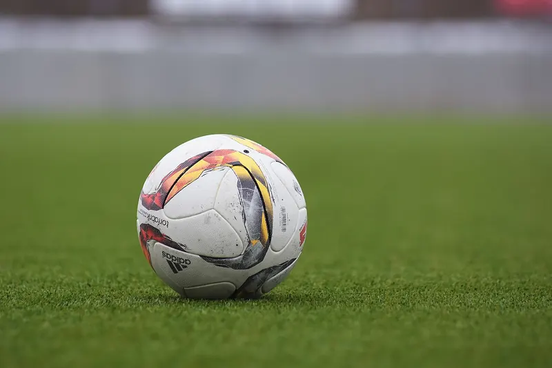Laptop med fotbollsmatch och anteckningsblock inför dagens spel